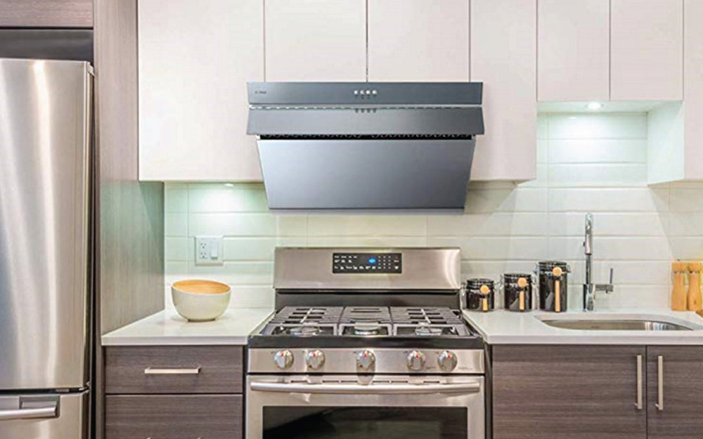 JQG02 Series 30-inch range hood under white cabinets above a stainless steel stove.