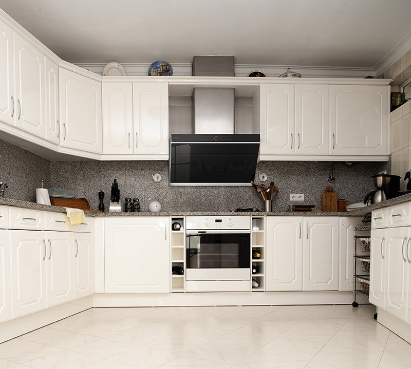 FOTILE JQG01 range hood above a stainless steel stove in a white kitchen.