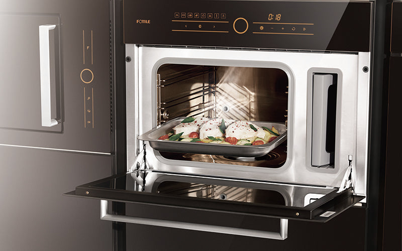 Horno de vapor empotrado SCD42-F1 negro con bandeja de pescado y verduras en su interior.