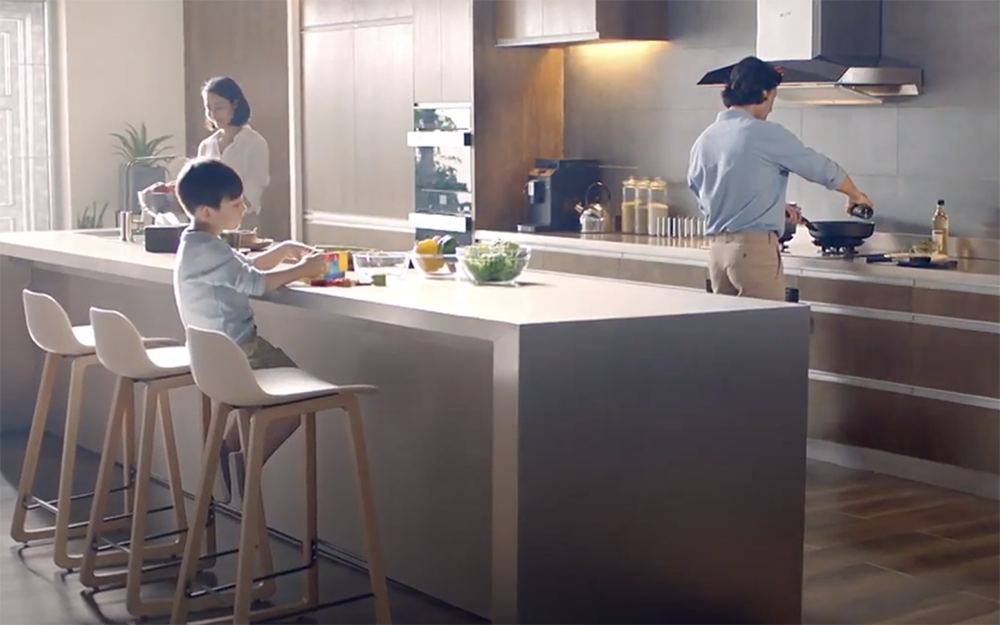 一家人在装有EMG9030抽油烟机的现代厨房里烹饪晚餐。