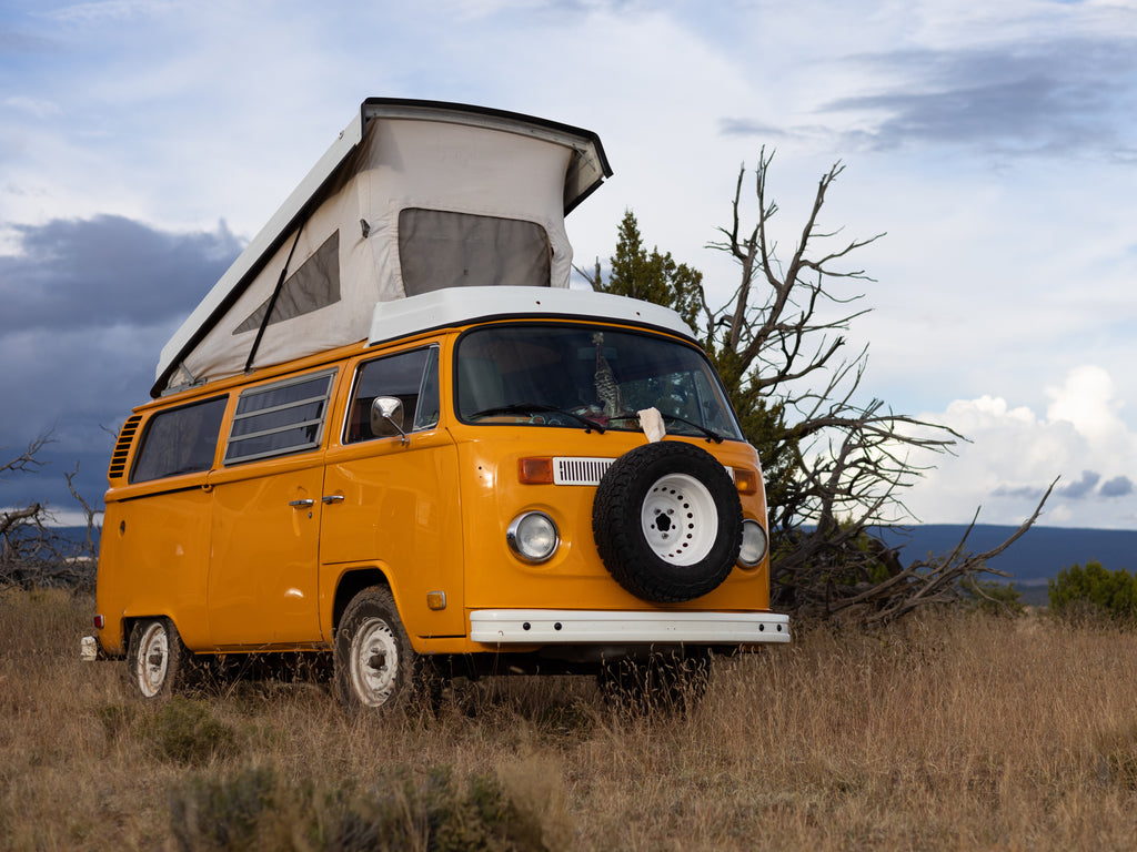 Volkswagen pop-top campervan with the top up in a high desert environment..