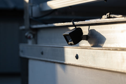 A close-up of KC Hilites Flood Lights mounted on the side of a camper van.