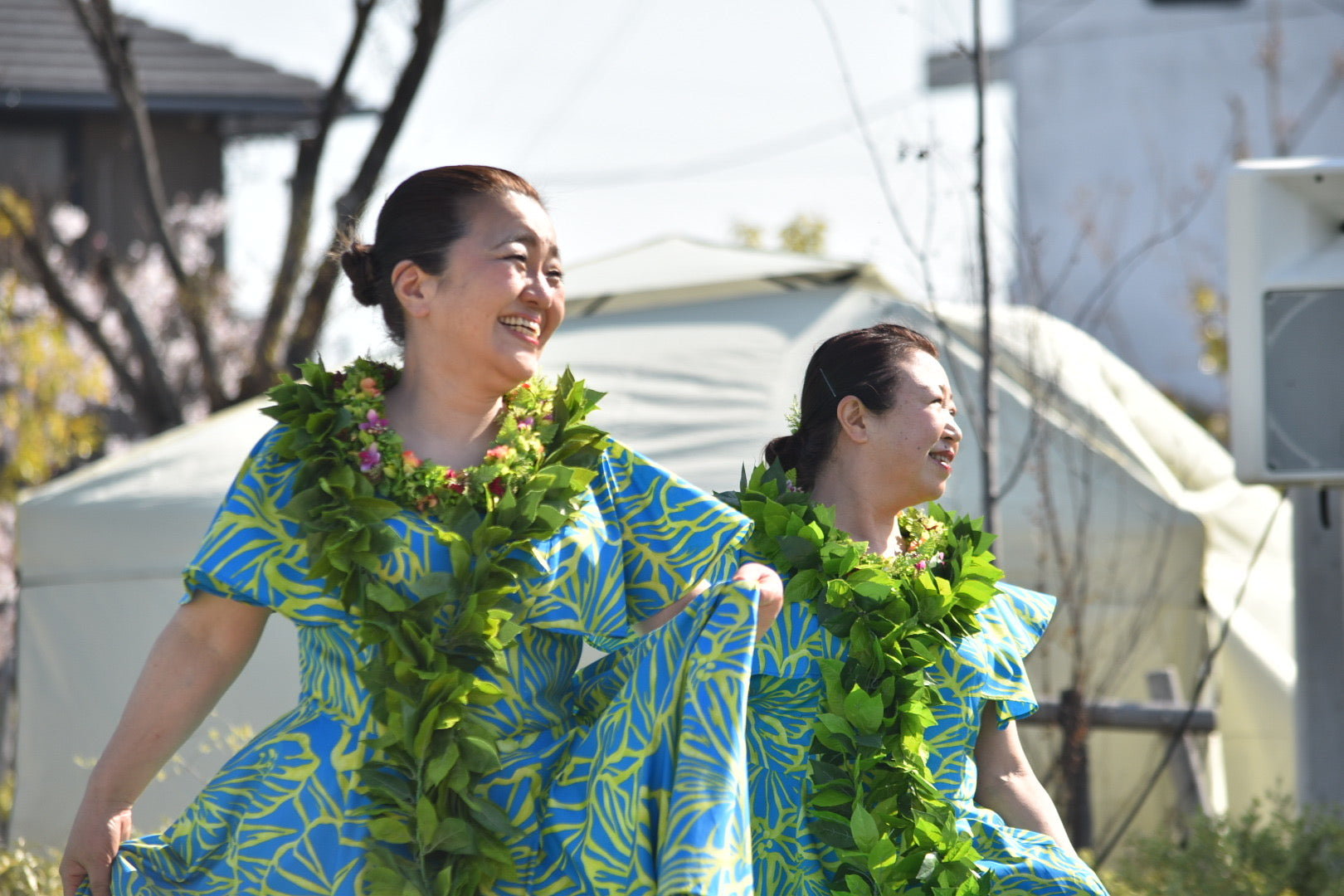 二人の女性が笑顔でフラダンスを踊っている様子