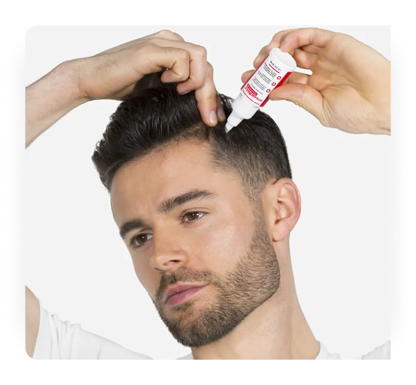 Immagine dell'uomo che applica il siero concentrato EMUAIDMAX®️ sul cuoio capelluto