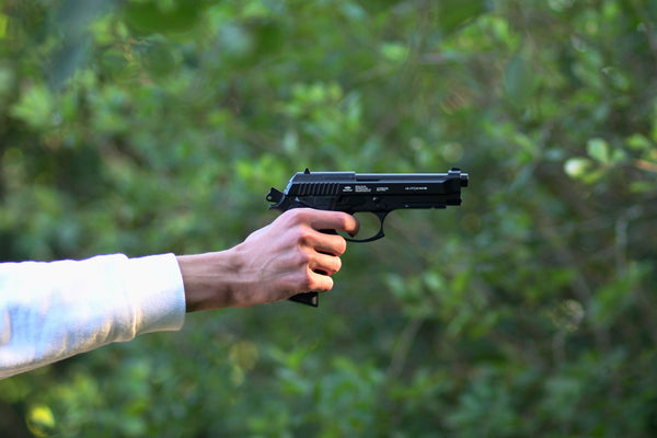 man holding beretta pistol