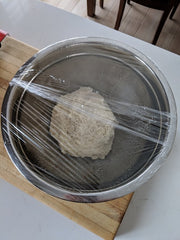 Pizza dough rising in bowl