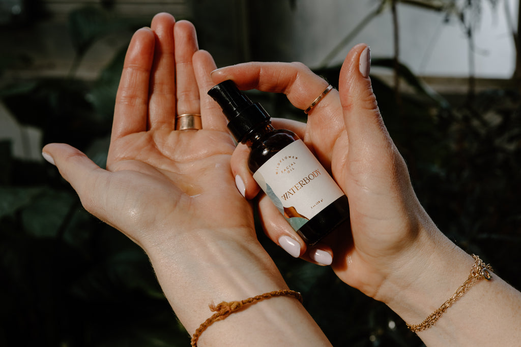 A woman pumps wildflower facial oil into her hand