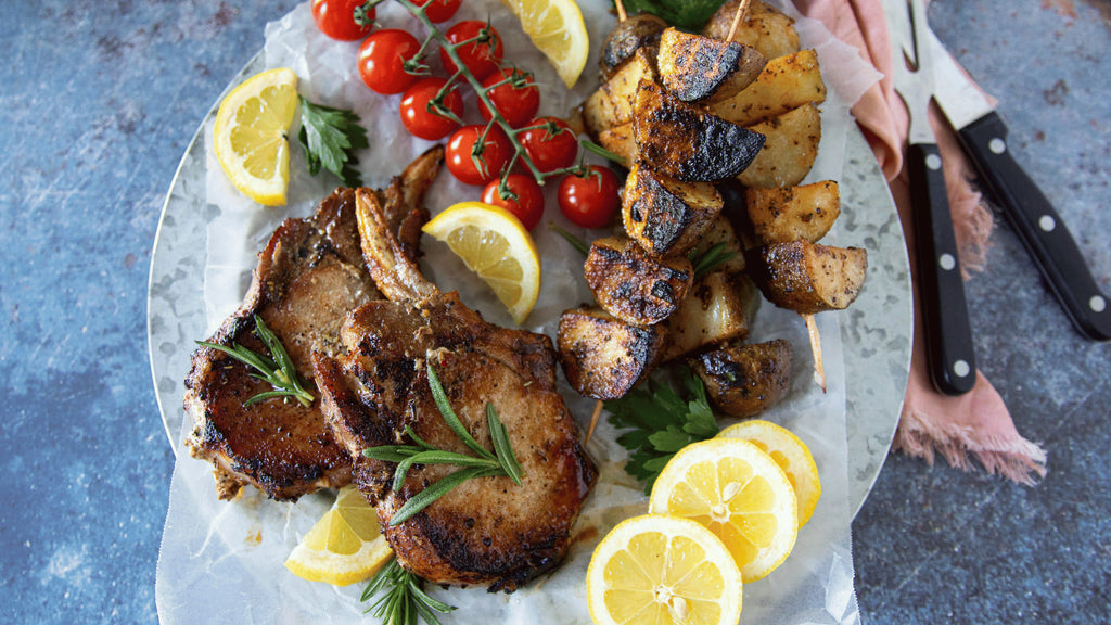 A spread of grilled french cut pork chops with crispy potatoes