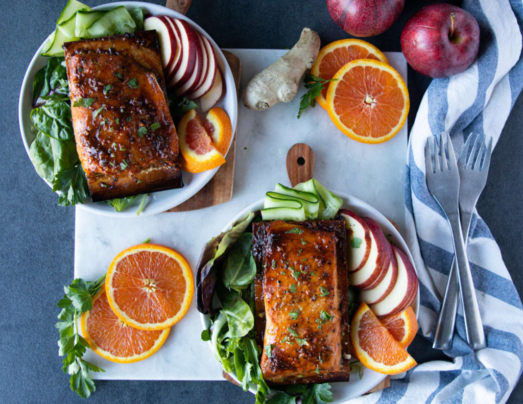 Sealand personal salmon on cedar planks with salad and fresh orange slices