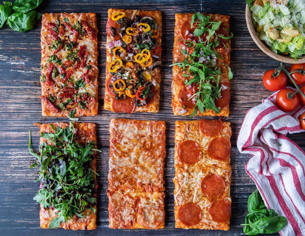 Selection of Sealand wood fired personal pizzas on a platter with garnish