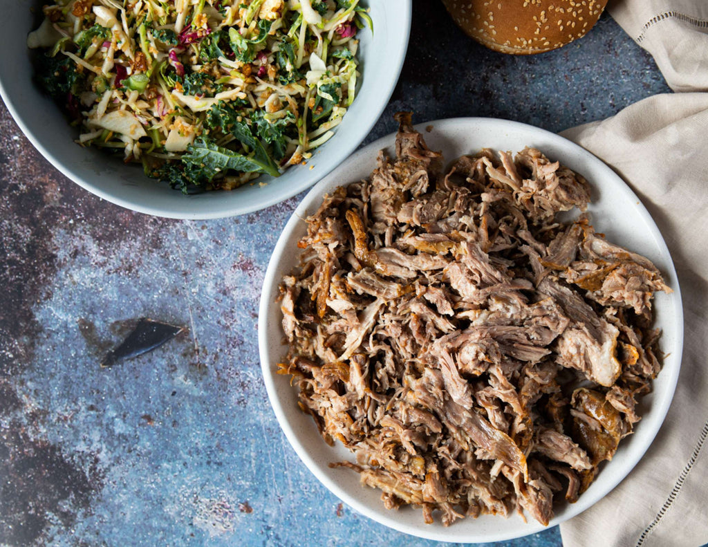 Sealand pulled pork in a bowl alongside a second bowl of coleslaw