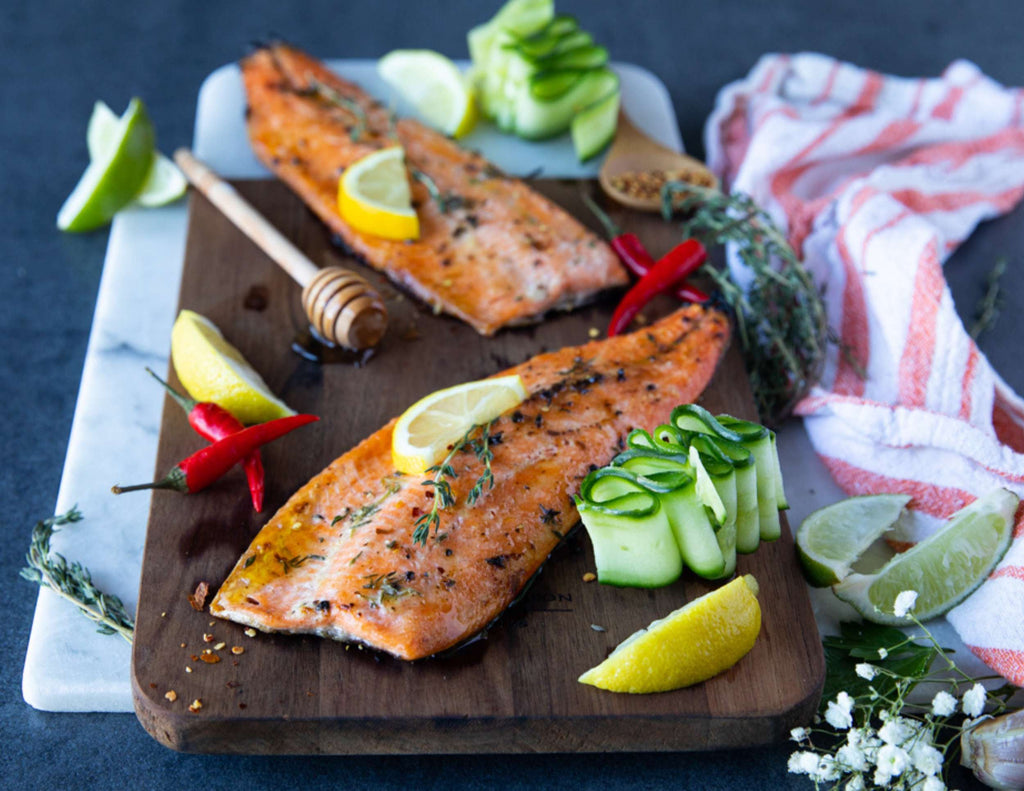 Sealand rainbow trout fillets on a wooden board with garnish