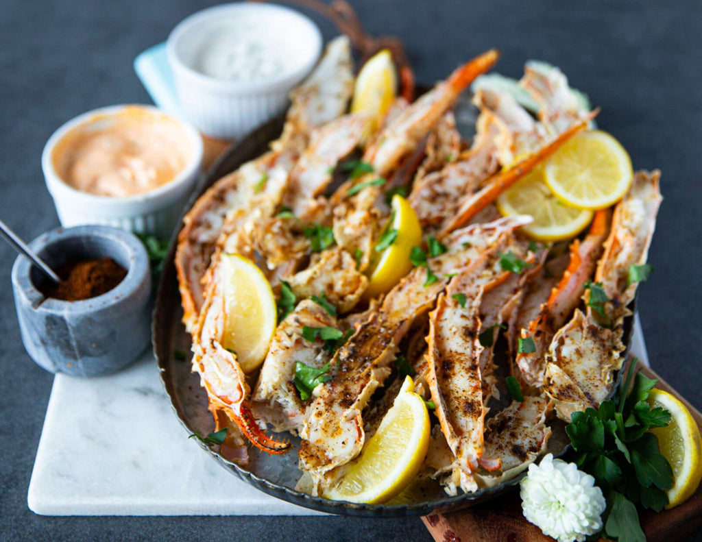 King crab legs on serving platter with fresh lemon and dips