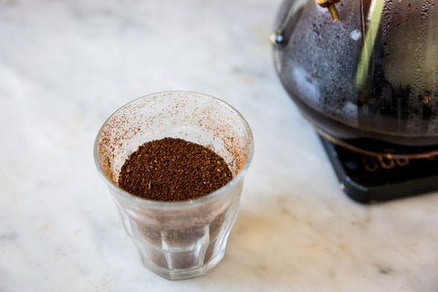 Ground coffee in a small glass cup