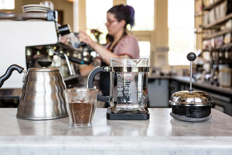 barista behind the bar with French press