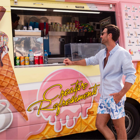 man standing at ice cream van wearing board shorts and linen shirt