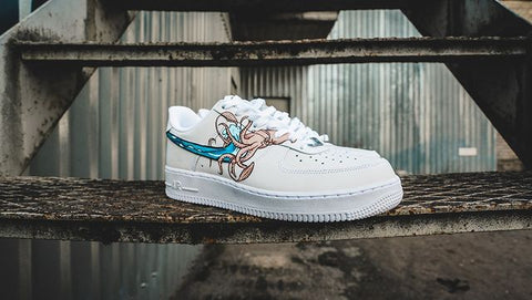 custom white air force 1 sneakers by wokecustoms featuring a custom squid design with a street background