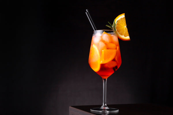 aperol spritz in cocktail glass on black table