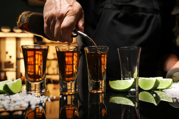bartender pouring tequila into glasses