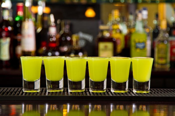 row of green tea shots on a bar