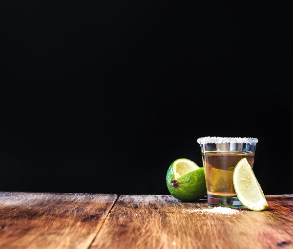 shot of tequila with salted rim and lime with a slice cut out