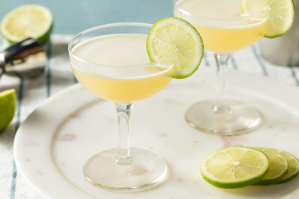 two vodka gimlets with lime slices on serving tray