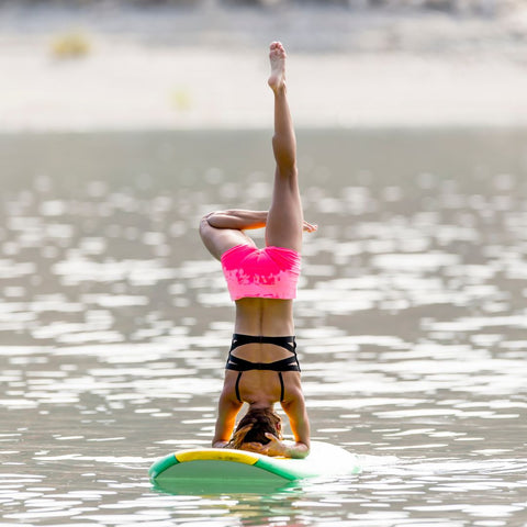 Someone doing yoga on a paddle board.