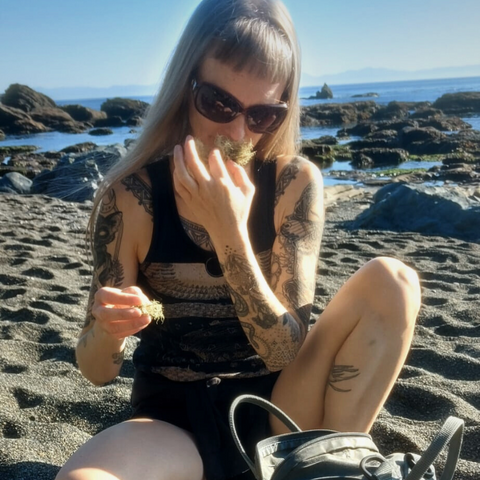 Jess smelling lichen on a sunny beach