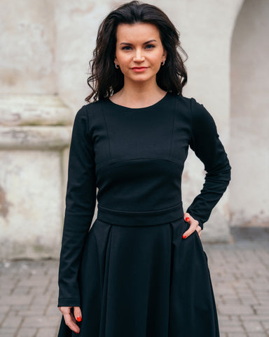 Baiba wearing classic two-piece black dress with long sleeves