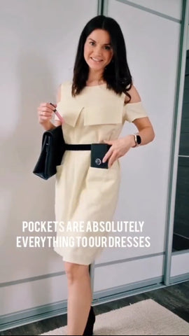 lady in a yellow dress with black belt, black clutch bag and a phone in hands