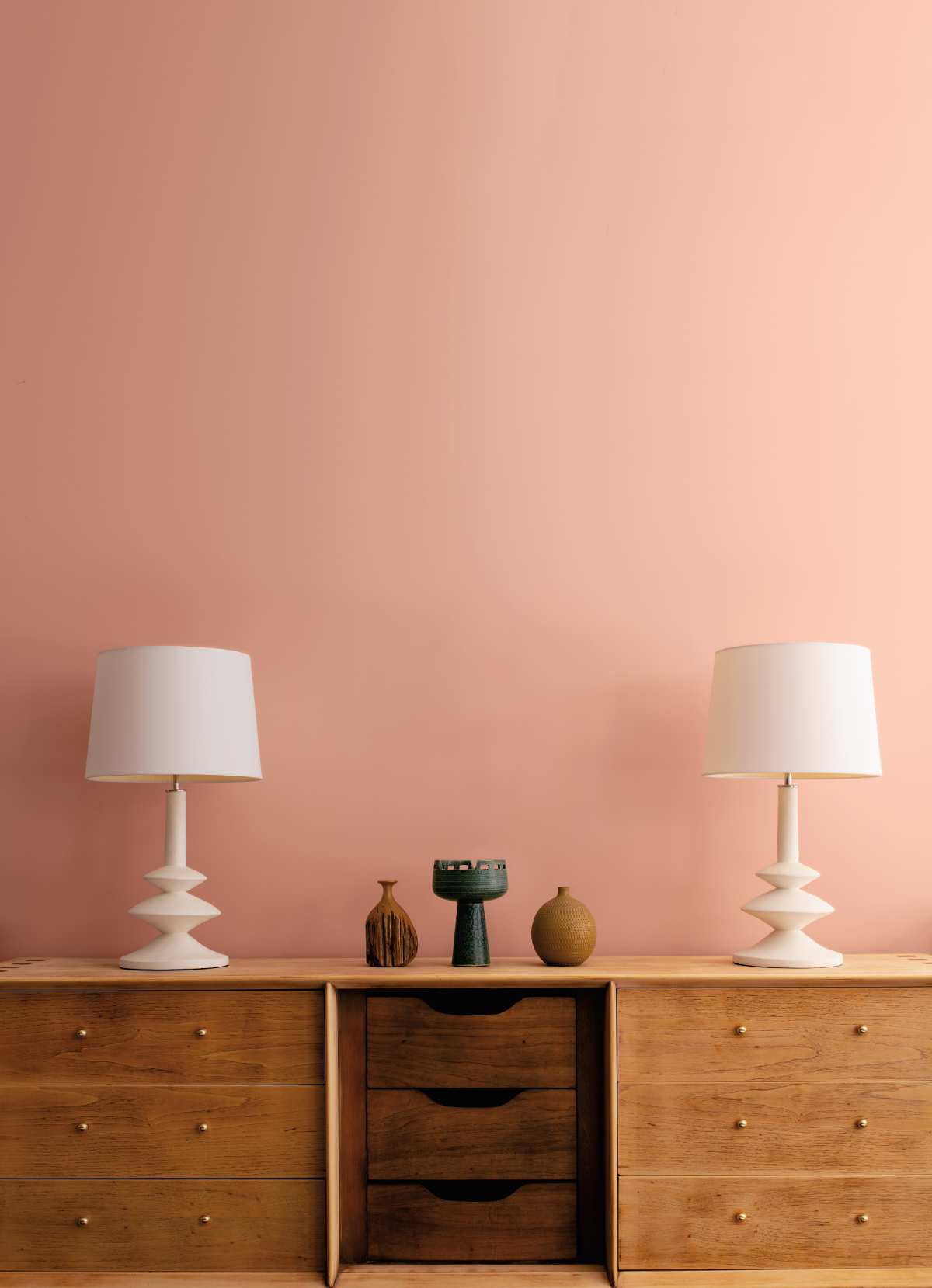 Two lampshades on a chest of drawers