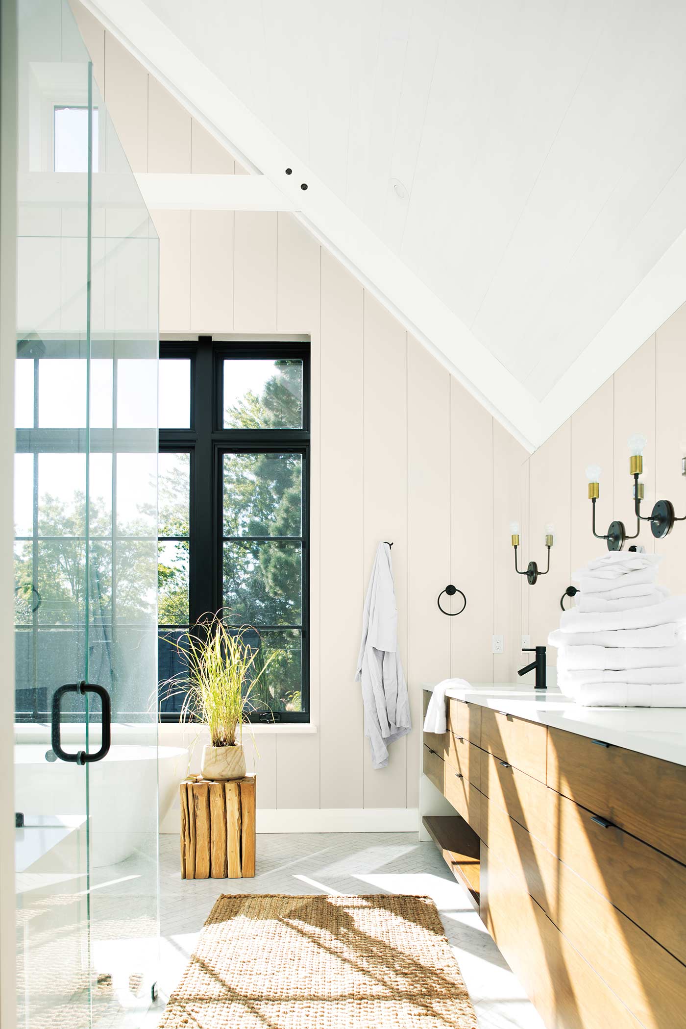 bathroom with basin and white towels on a shelf to the right and a glass shower door to the left