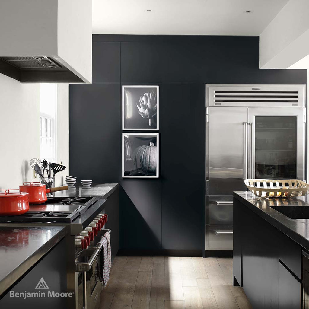 a modern kitchen with stainless steel appliances and black walls