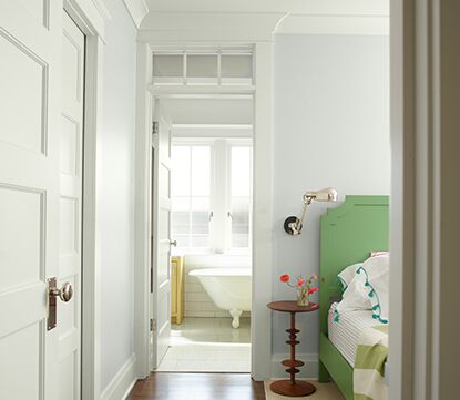 white painted bedroom with green painted bed headboard