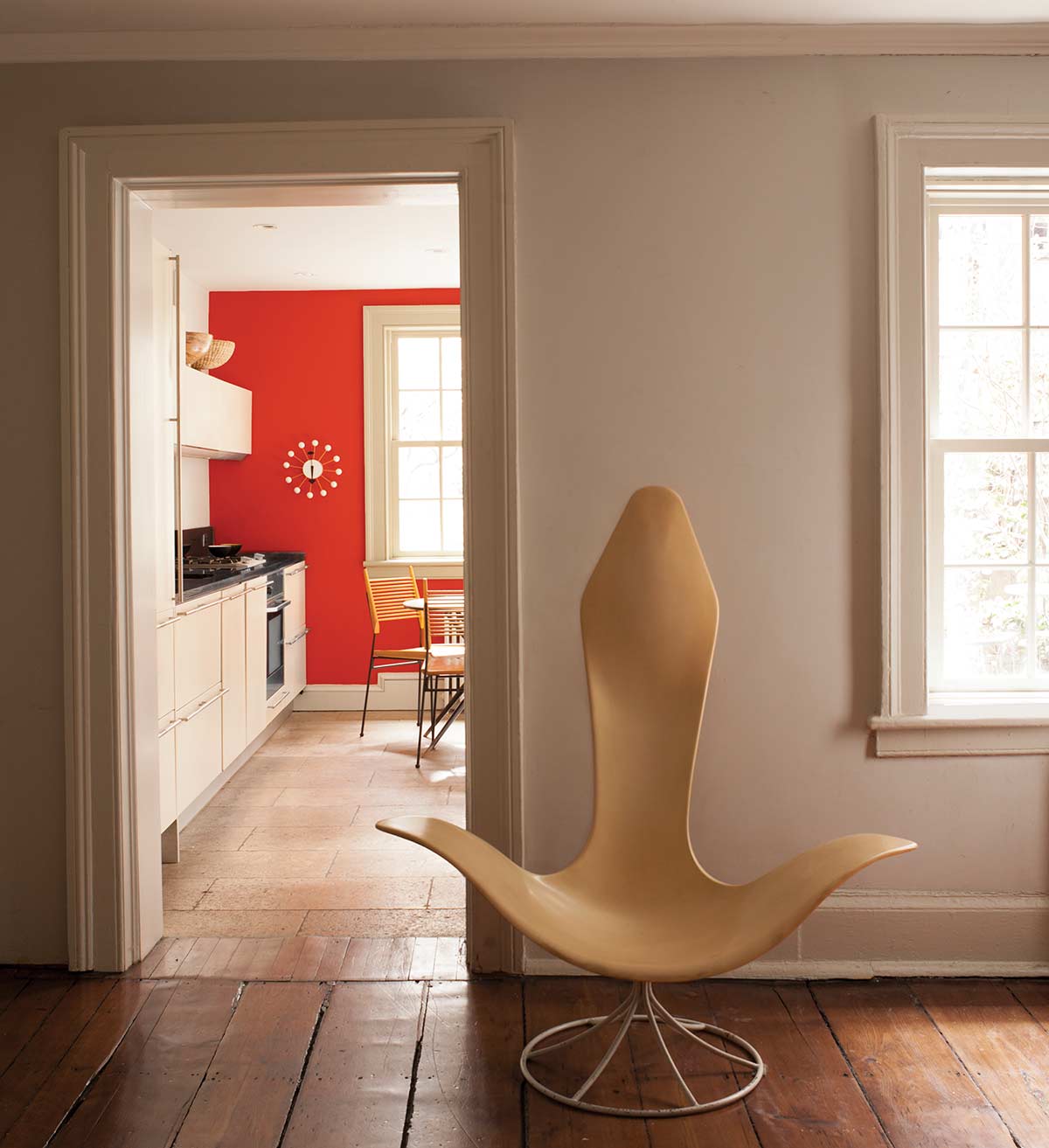 partial view of kitchen through doorway with vibrant orange/red wall