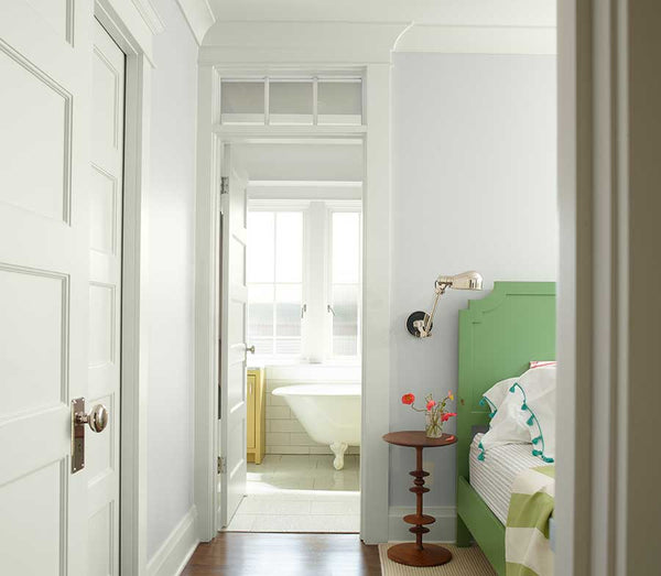 bedroom with white walls doors and a bed with green backboard and frame
