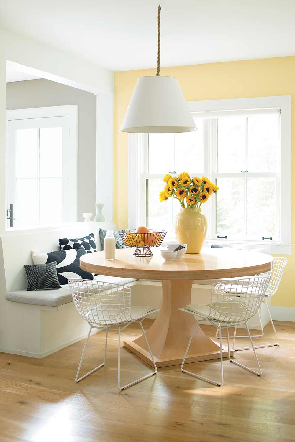 small kitchen table in front of a window with bench seating