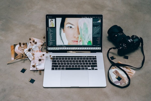 woman photo editing laptop next to camera lightroom presets