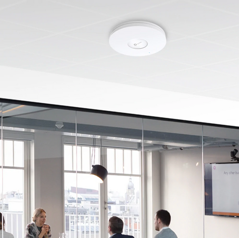 a wireless access point attached to a ceiling in an office space