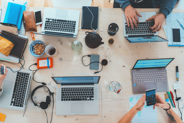 aerial view of a table full of laptops and other tech