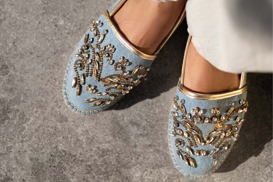 This is an image of a pair of beautiful embellished ladies shoes of blue color wore by a model