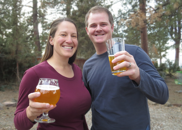 Valarie and Nate holding beer from Bevel Craft Brewing.
