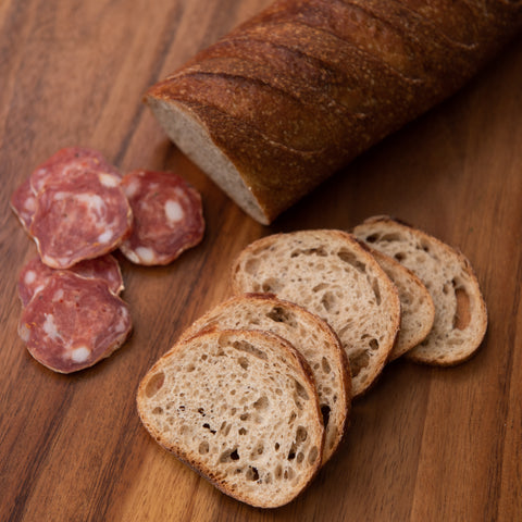 A freshly baked loaf of classic Rye bread, with a dark crust and a dense, chewy texture. Perfect for slicing and serving with cold cuts and cheese platters, or as a hearty addition to any sandwich.