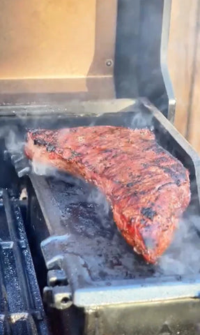 Steak searing on the AutoIgnite charcoal hopper lid