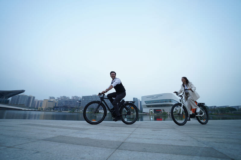 a gentlement riding an engwe p275 pro and a lady riding an engwe p275 st commuter bikes