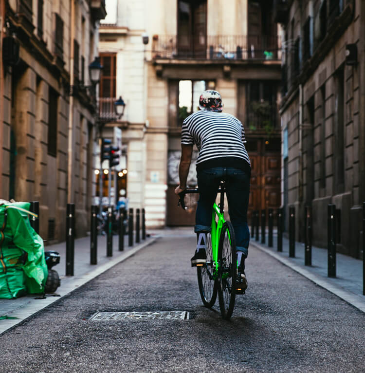 a man wearing a helmet rides a green electric bike on the road