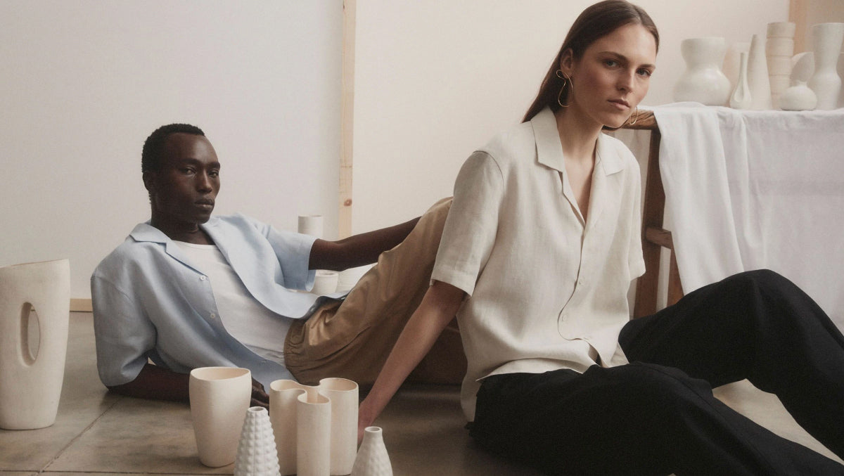 Photo showing two models seated wearing Riley Studio shirts (made from sustainable materials)