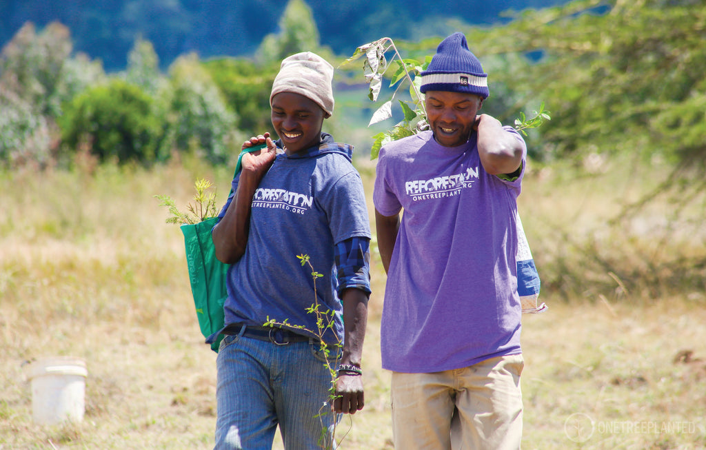Two men in a field wearing reforestation t shirts