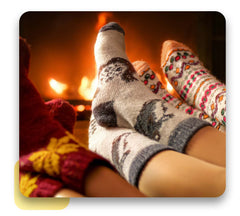 A family wearing matching socks sits by a fireplace.
