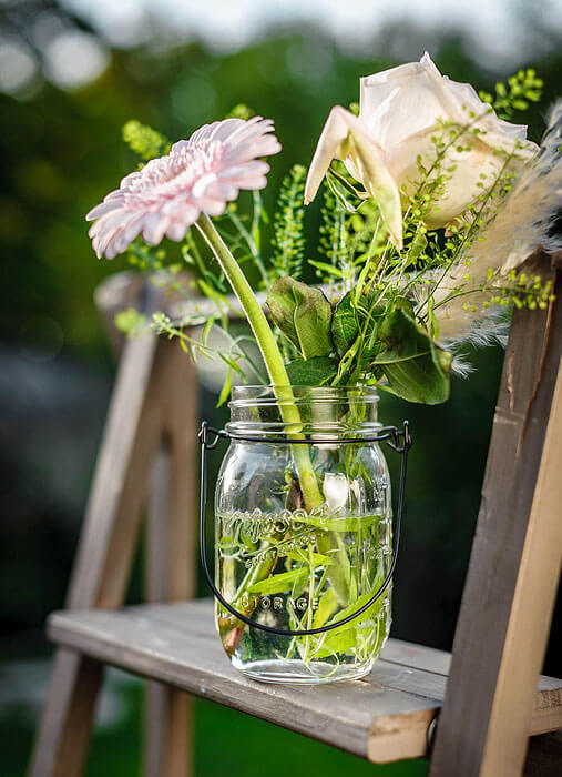 pot en verre avec anse et fleurs